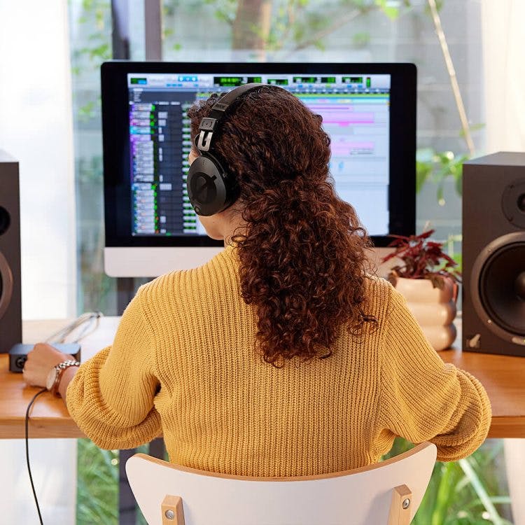 Rode NTH-100 headphones being used for music production in home studio with DAW on screen