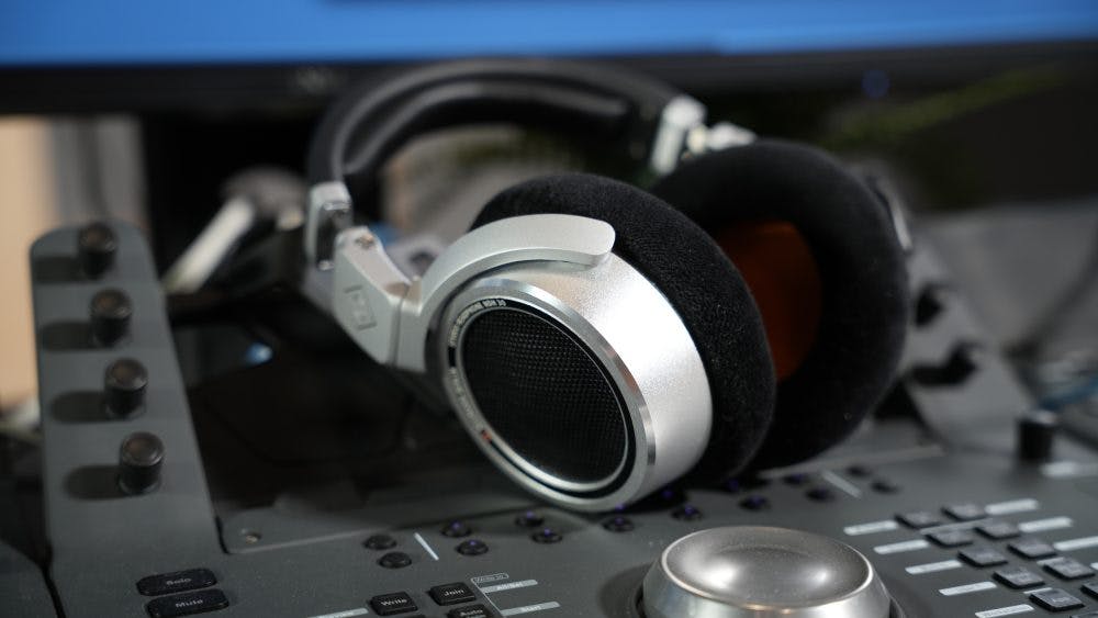 Neumann NDH 30 headphones on professional audio control surface with studio mixing equipment